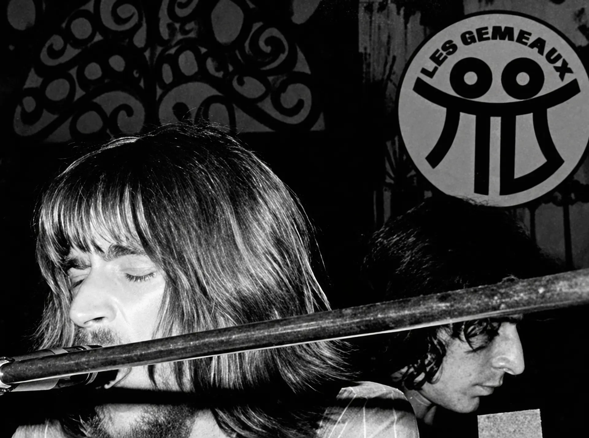 Brian Auger au clavier sur la scène des Gémeaux, à Auderghem, sous le sigle du club peint au mur. Julie Driscoll et Brian Auger comptent parmi les artistes passés par cette salle avant qu'elle ne devienne Le Canotier puis Le Cactus.