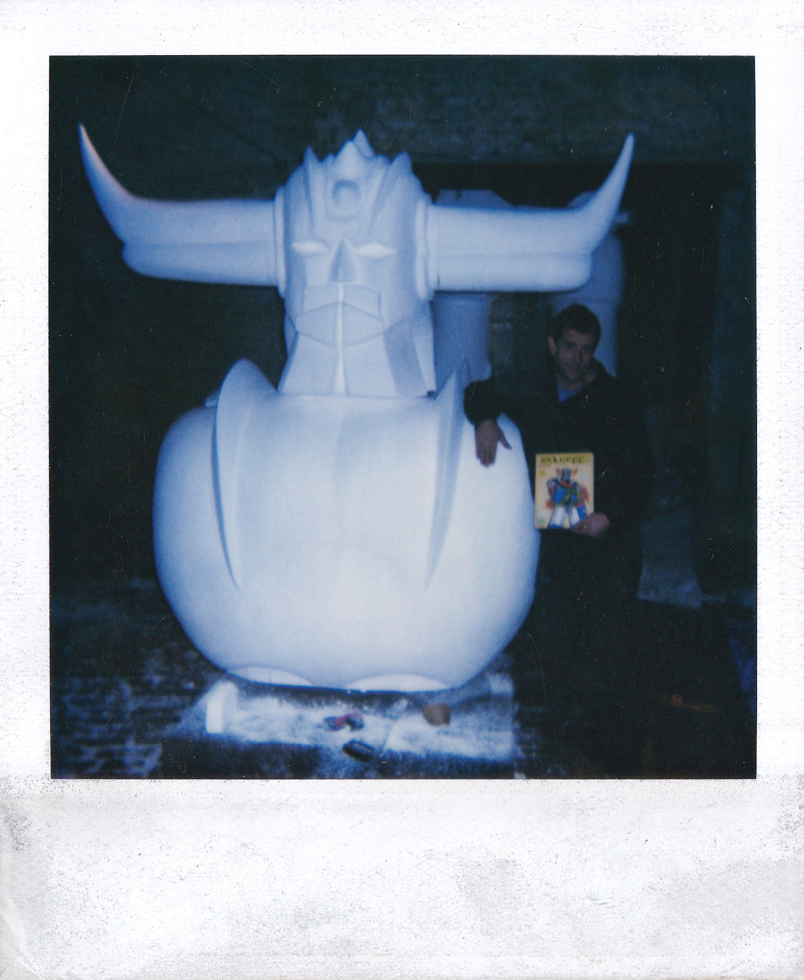 Pierro Vandermeeren in front of the assembled structure, holding the Goldorak figure used as the model.