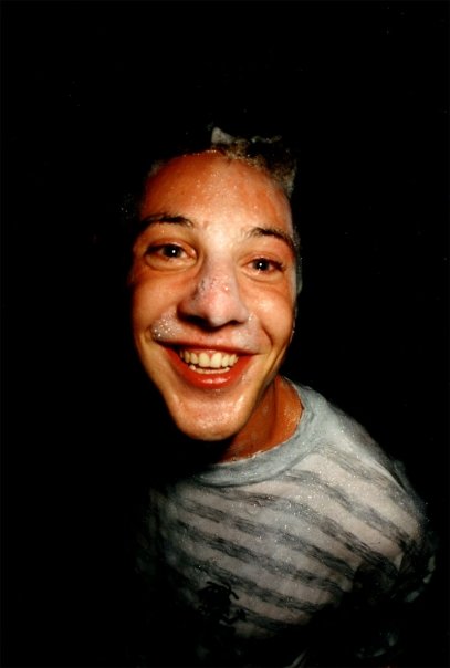 Portrait of a smiling clubber, face and striped T-shirt covered in foam.