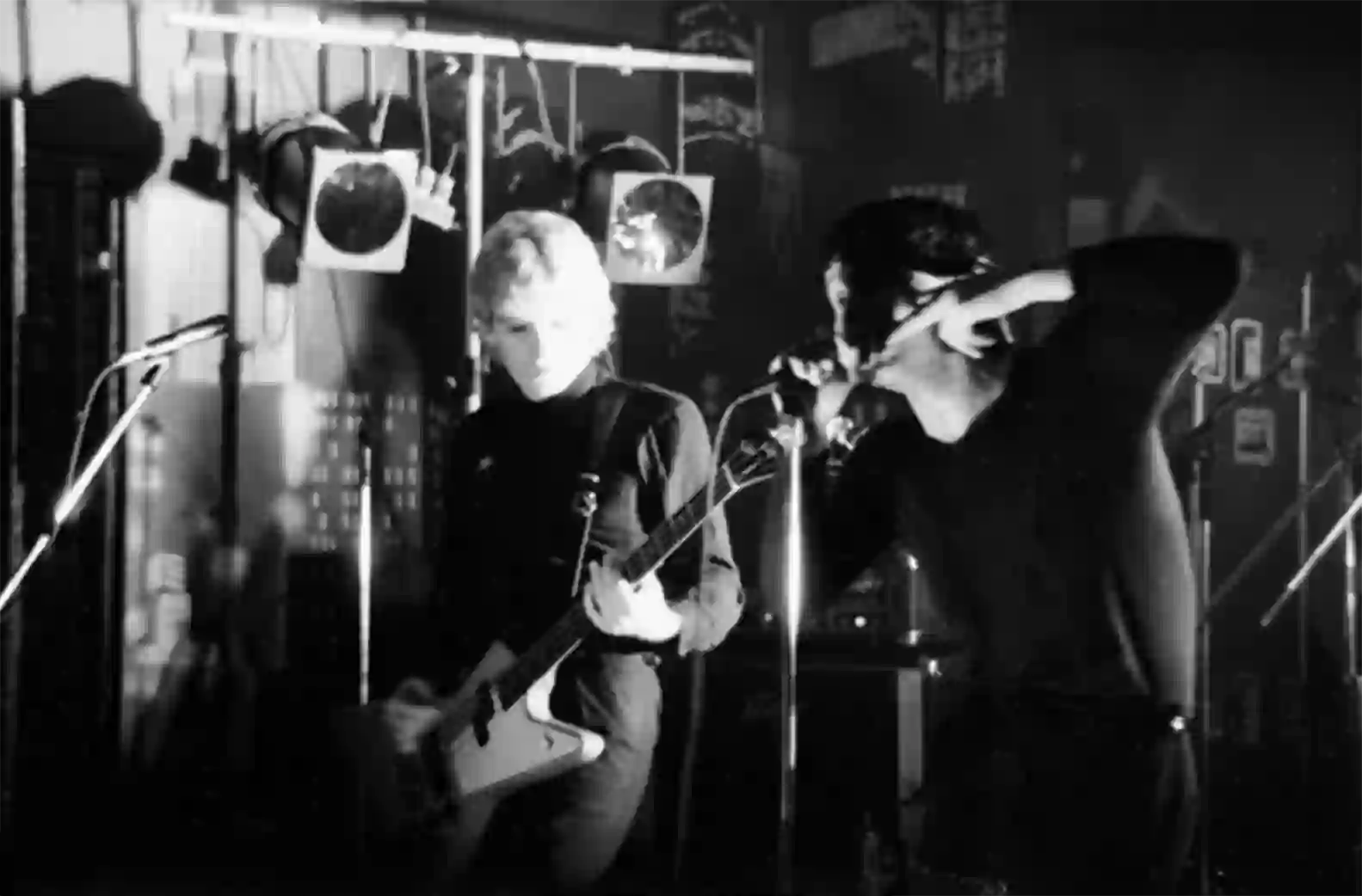 Derek Forbes à la basse et Jim Kerr au chant, sous les projecteurs et les miroirs suspendus du décor du Canotier.