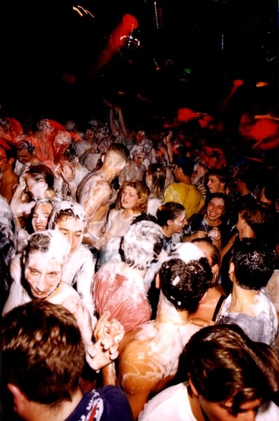 The floor packed, seen from above, the crowd caught in the foam.