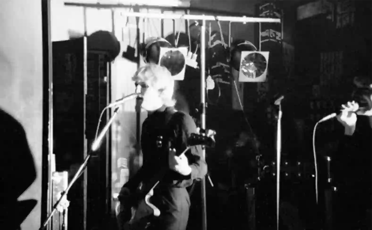 Derek Forbes au micro devant le parc de projecteurs et les disques miroirs suspendus du Canotier.