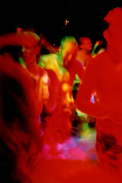 The floor in motion, silhouettes caught in the red light.