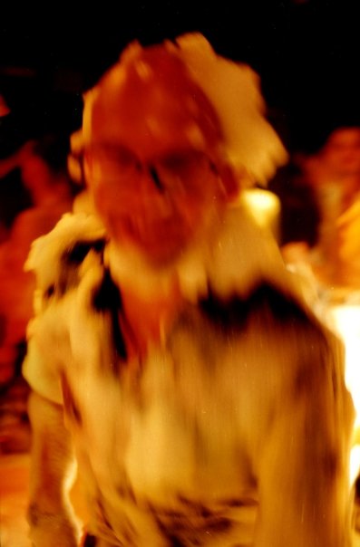 Blurred portrait of a clubber covered in foam, in the amber light of the club.