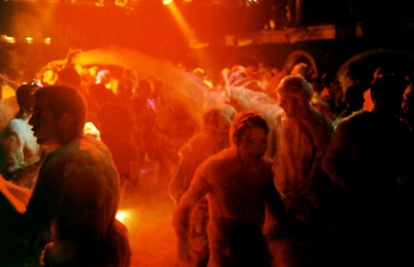 The jet of foam crosses the room above the dancers.